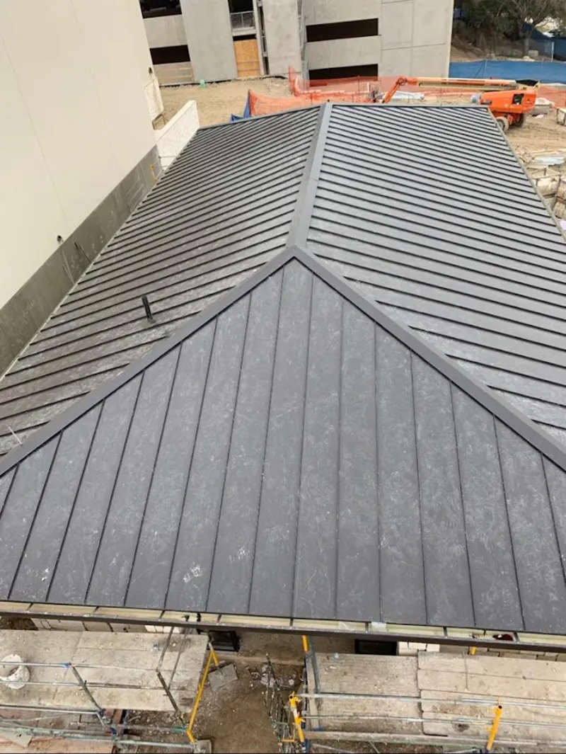 Commercial metal roof construction with crane equipment in Niles